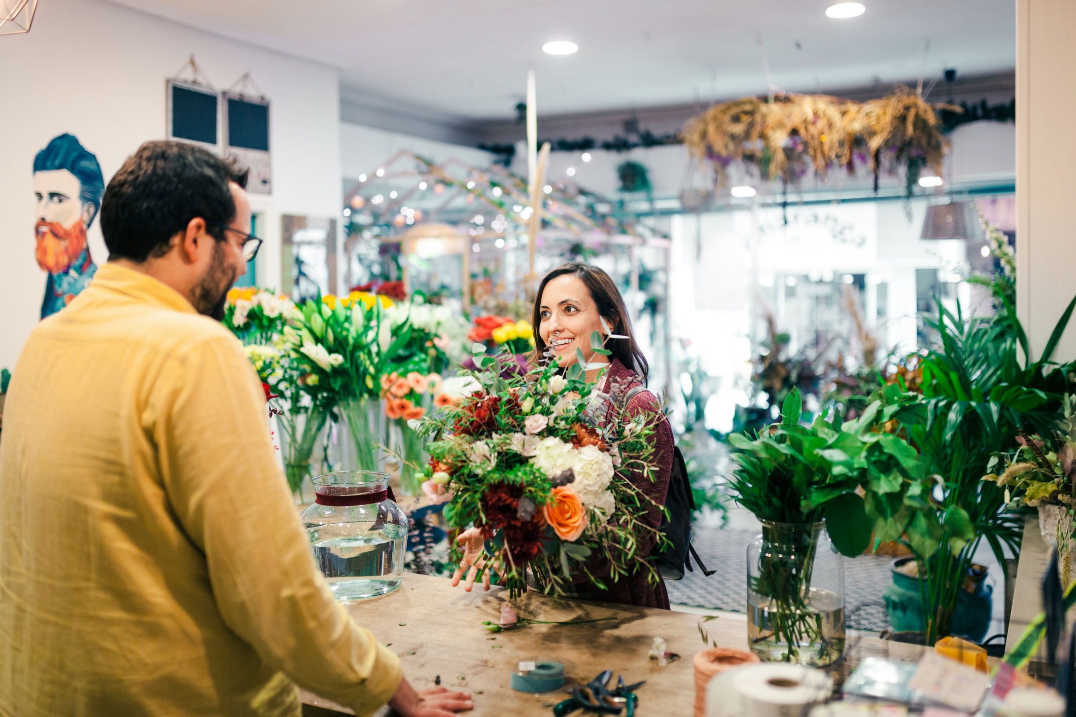 Customer buying a bouquet of flowers in a florist's storefront shop