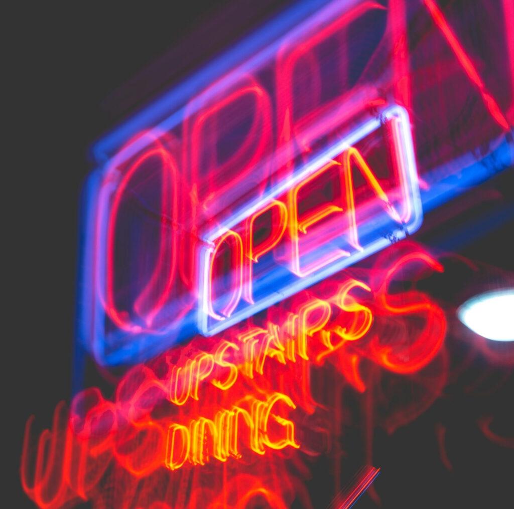 Hero image of neon "OPEN" restaurant signage.