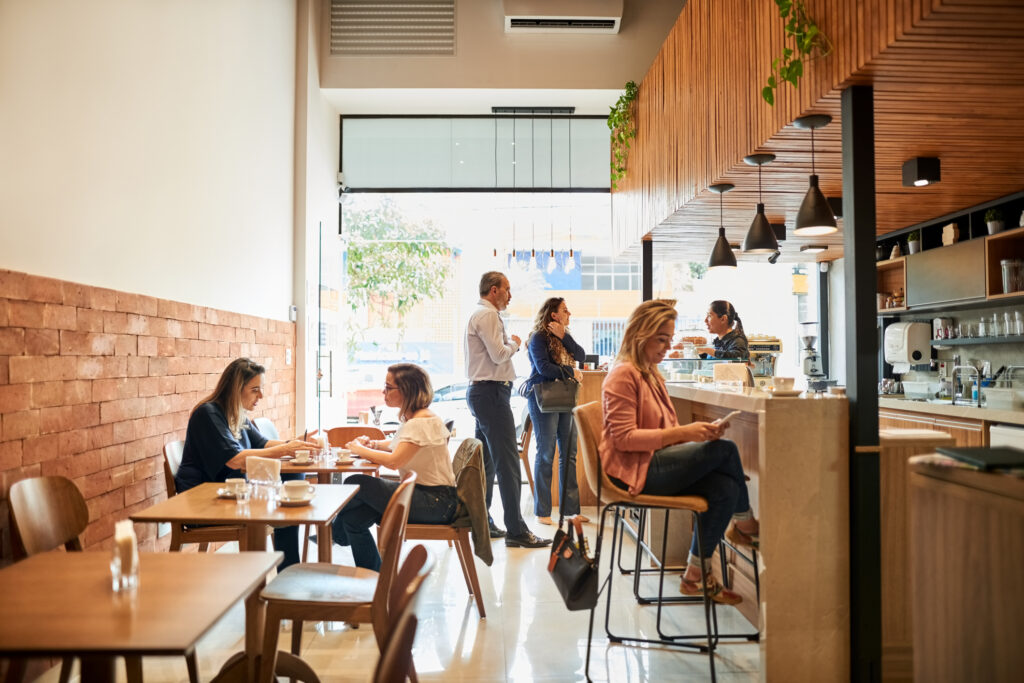 Interior shot of a small cafe with one employee at the counter.
